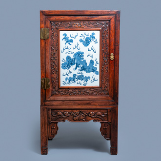 Un cabinet en bois hongmu incrusté d'une plaque en porcelaine de Chine en bleu et blanc, 19ème